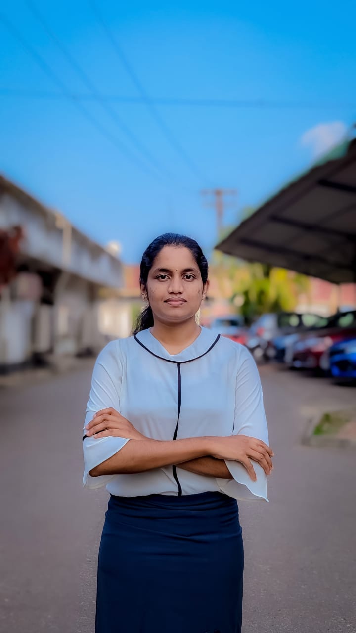 Portrait of Yoghanathan Savitha Harini, Vice President of the Tamil Student Association, smiling and wearing formal attire, standing in a university or event setting. If visible, text in the image: Yoghanathan Savitha Harini Vice President. The atmosphere is welcoming and professional.