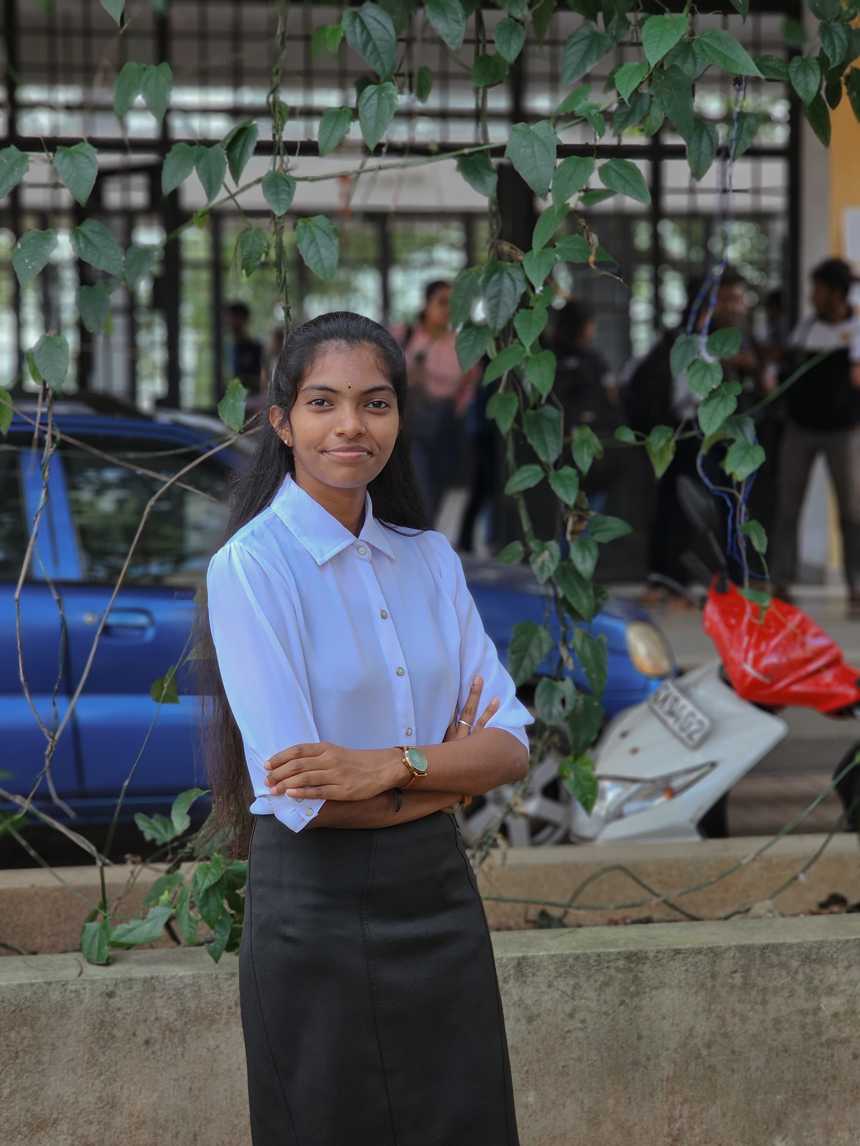 Portrait of Chankavi Thayananthan, Committee Member of the Tamil Student Association, smiling and wearing formal attire, standing in a university or event setting. If visible, text in the image: Chankavi Thayananthan Committee Member. The atmosphere is welcoming and professional.